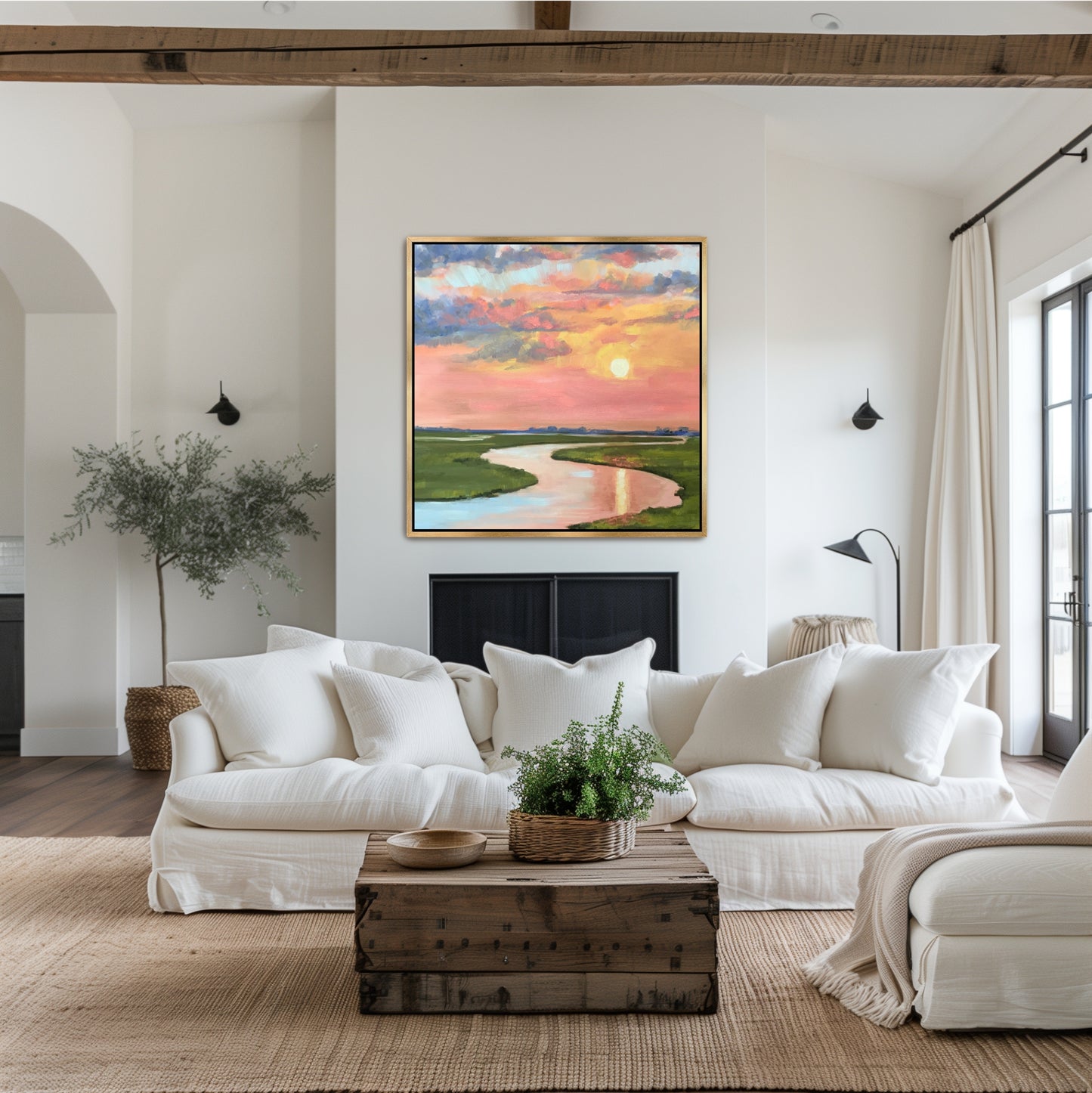 Charleston marsh sunset oil painting with melon and periwinkle sky in a gold floater frame, styled above a neutral sofa in a luxury coastal living room.