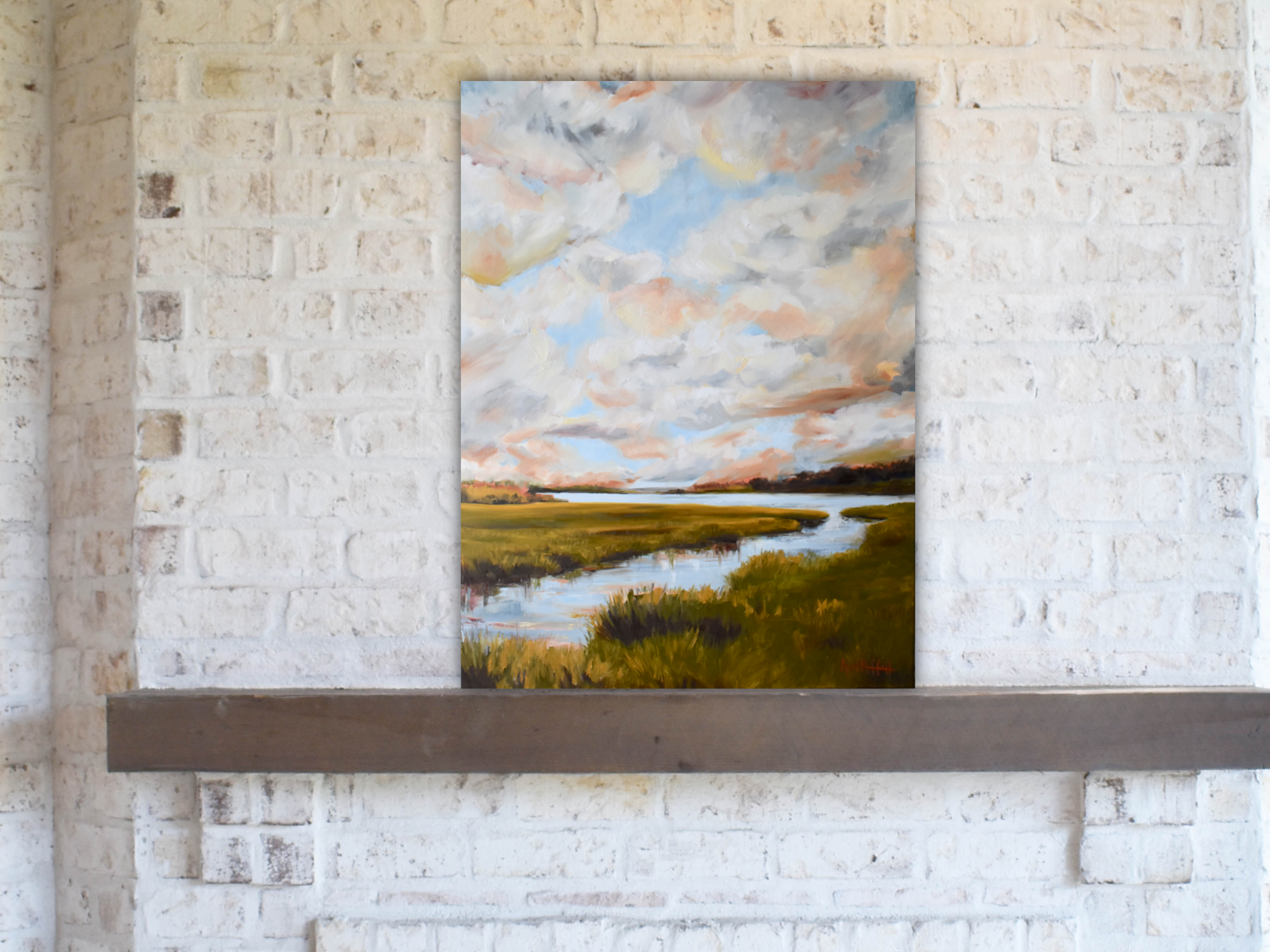 A gallery wrapped canvas of Lowcountry Marsh in warm colors like Sienna, gold, olive green, and ocher, on a stone mantle.