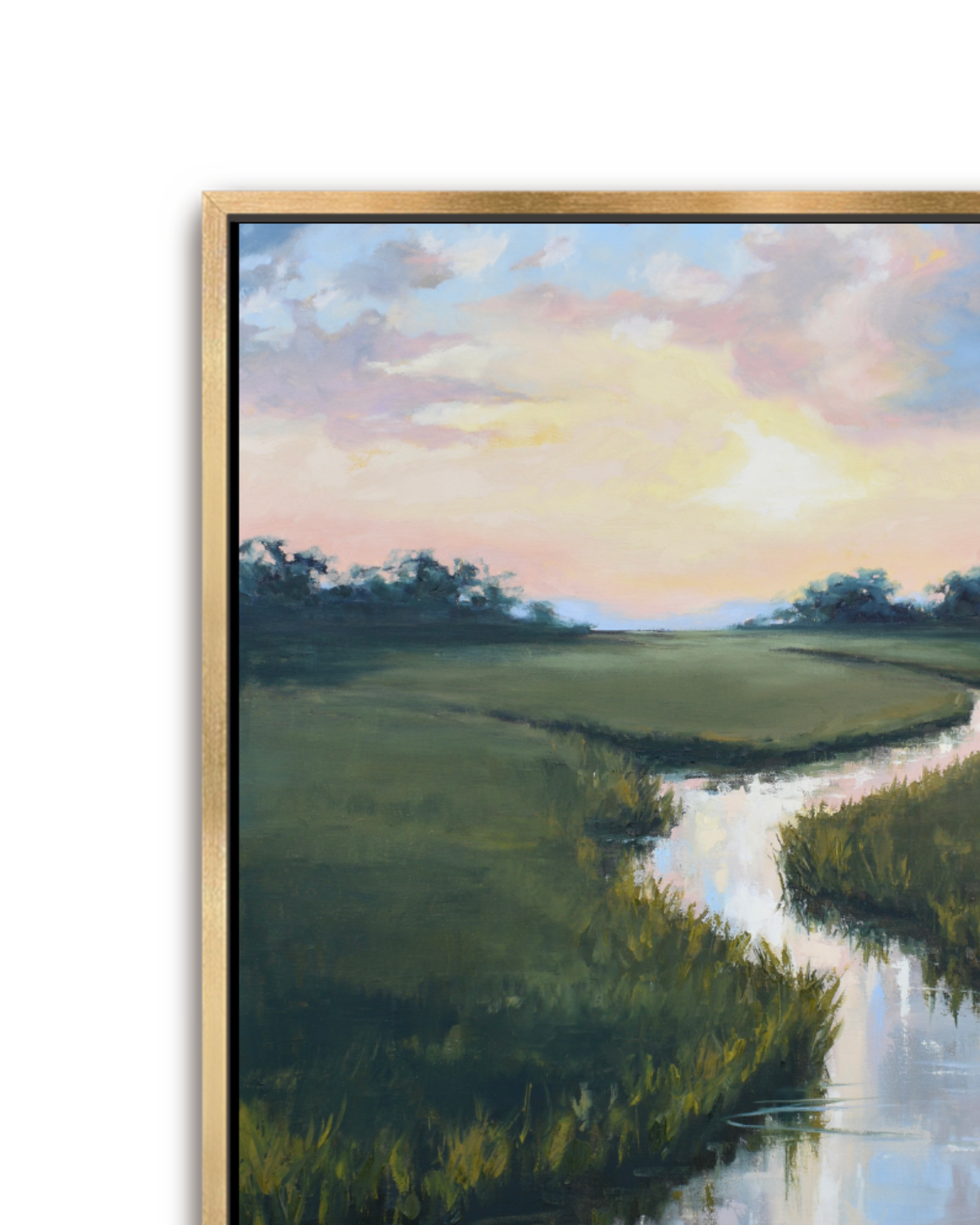 A framed landscape painting showing a winding river or inlet through a green marsh or golf course under a pastel sunset sky with pink, yellow, and blue clouds. The artwork is presented in a gold-toned frame against a plain white background.