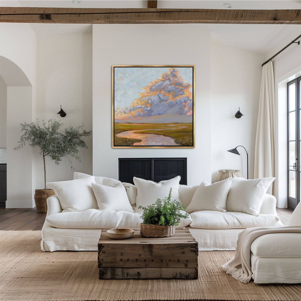 Large square Lowcountry landscape featuring pink and orange cloud reflections, framed in gold and styled as a focal point in an airy, sophisticated coastal living space.