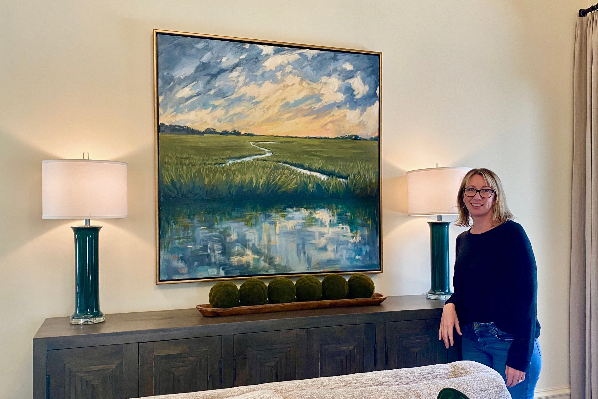 April Moffatt installing "Dusk on the Marsh" oil painting in a clients house in Savannah Georgia